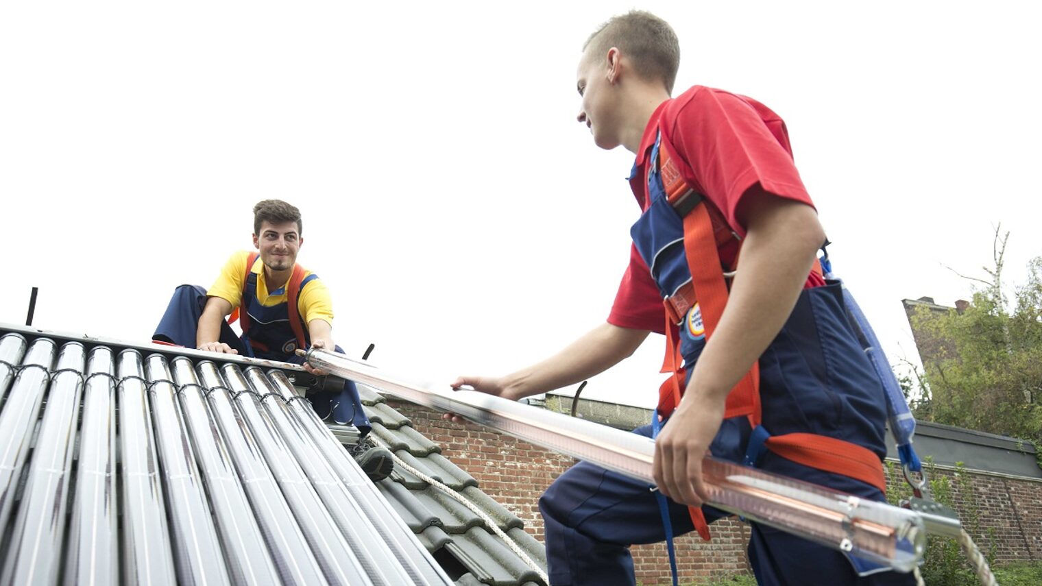 Zwei junge Männer auf einem Dach mit Solarmodulen