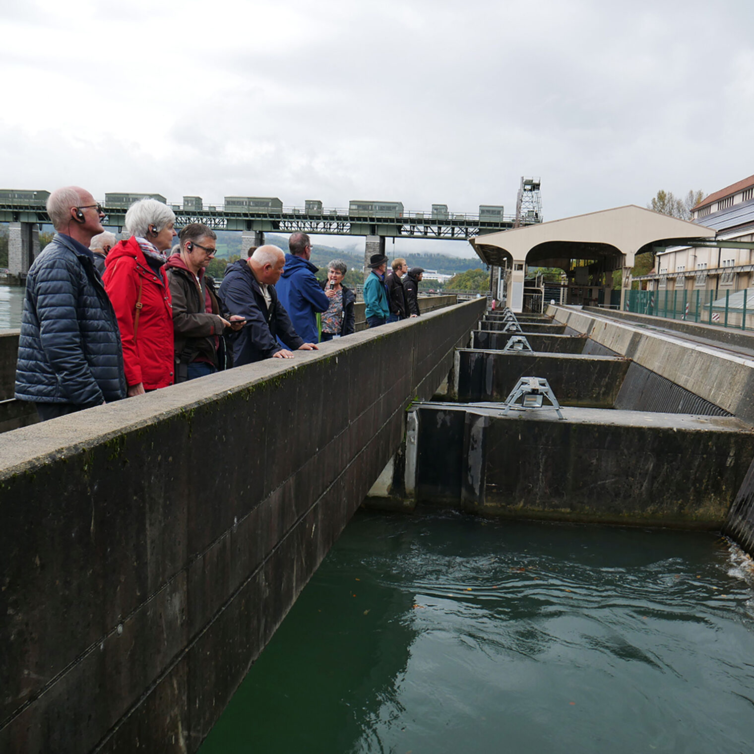Teilnehmer einer Exkursion der Handwerkskammer Konstanz stehen im Außenbereich des Wasserkraftwerks Wyhlen.