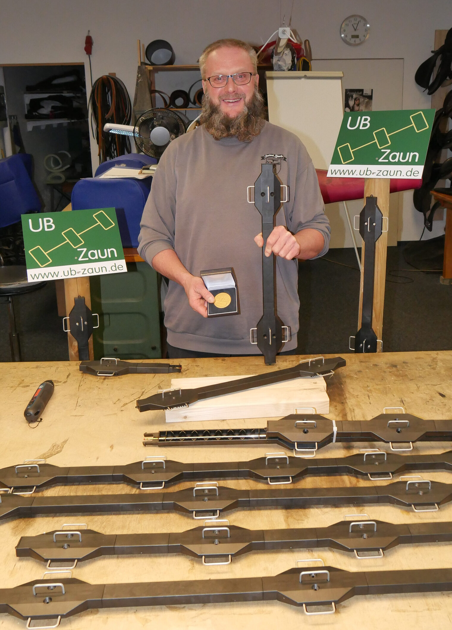 Mann in einer Werkstatt zeigt sein Werkzeug