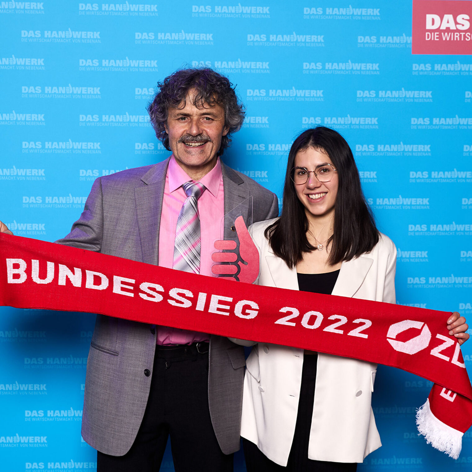 Bernhard und Sophie Muffler posieren vor der Fotowand auf der PLW-Bundessiegerfeier in Augsburg.