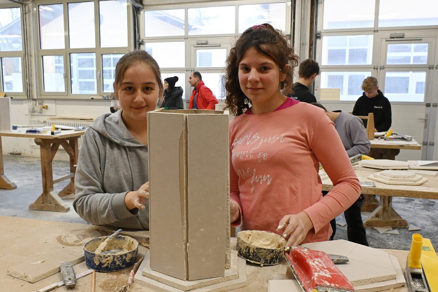 Zwei Mädchen bearbeiten eine Säulenunterkonstruktion