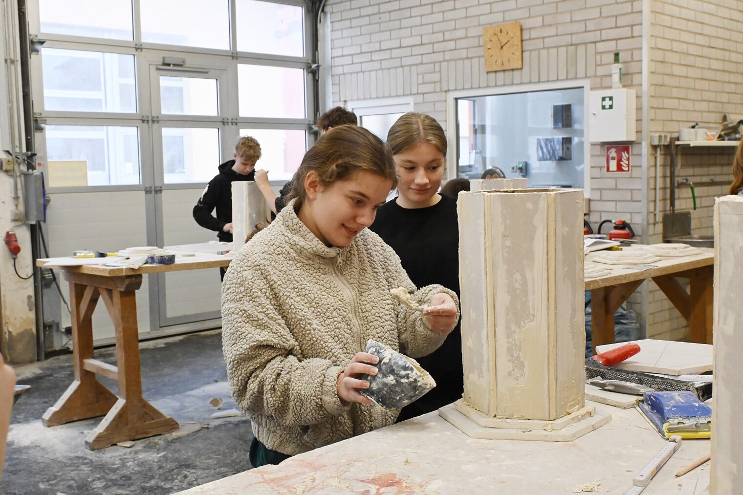 Zwei Mädchen bearbeiten eine Säulenunterkonstruktion