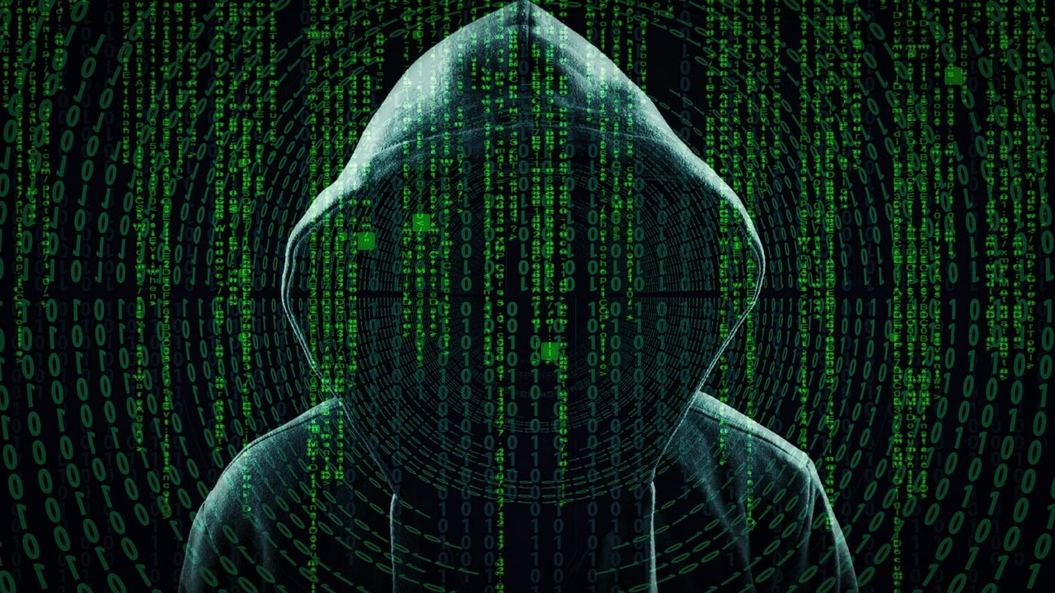 Symbolbild für Cyber-Angriff: Schemenhafte Person mit Kapuzenpullover hinter grünen Zahlenreihen.