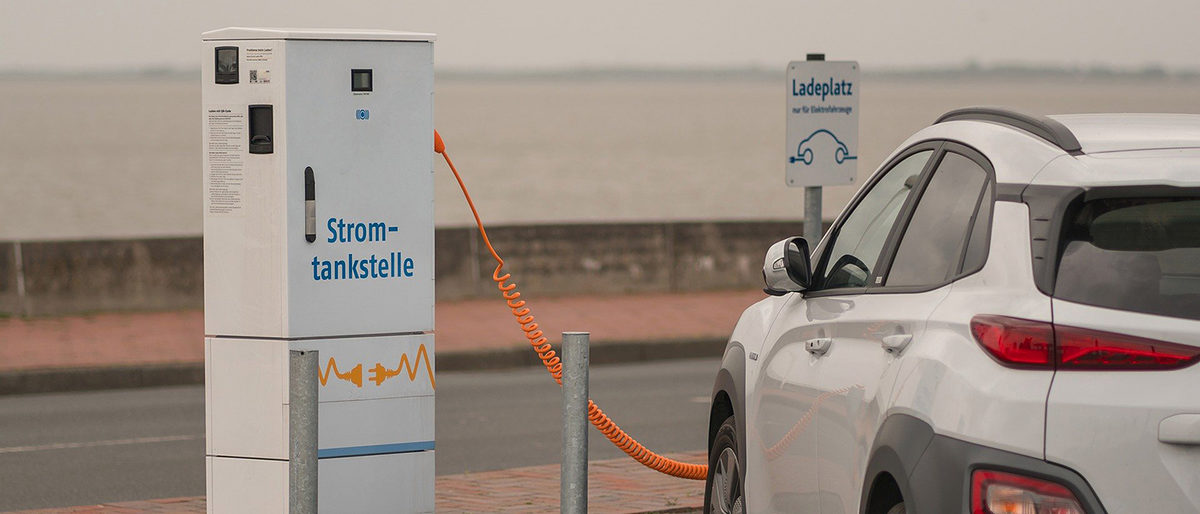 Anschaffung von E-Fahrzeugen wird bis Mitte September 2020 gefördert E-Fahrzeug steht an Stromtankstelle
