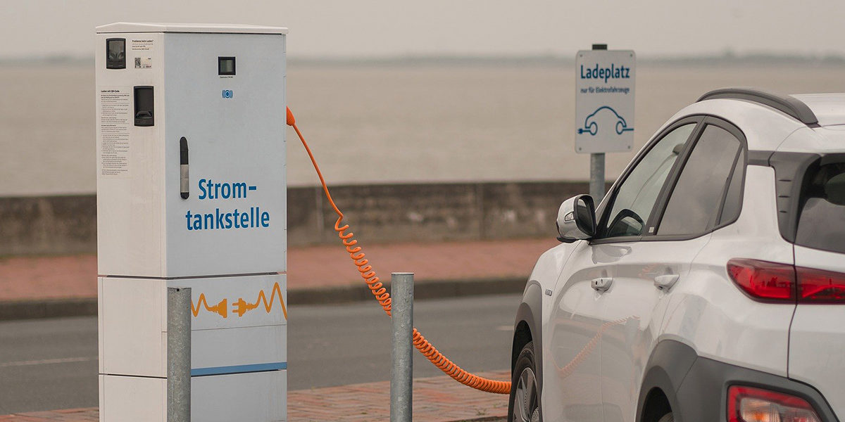 Jetzt attraktive Zuschüsse beantragen! E-Fahrzeug steht an Stromtankstelle