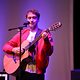 Mann singt und spielt Gitarre 