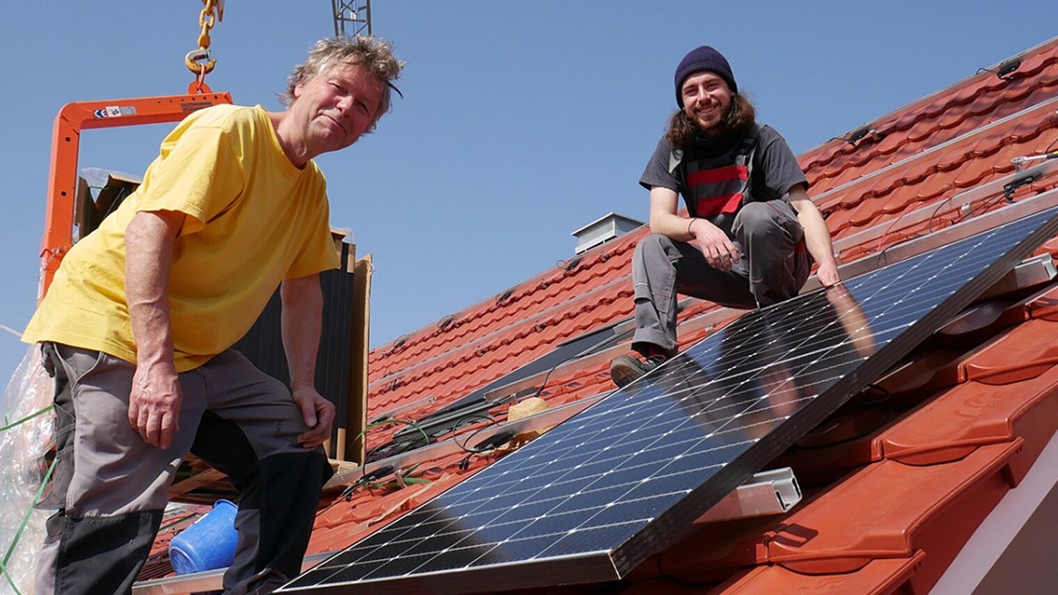 Michael Simon und Johannes Stiefel von Sunny Solartechnik auf einem Dach mit Solarpanel.
