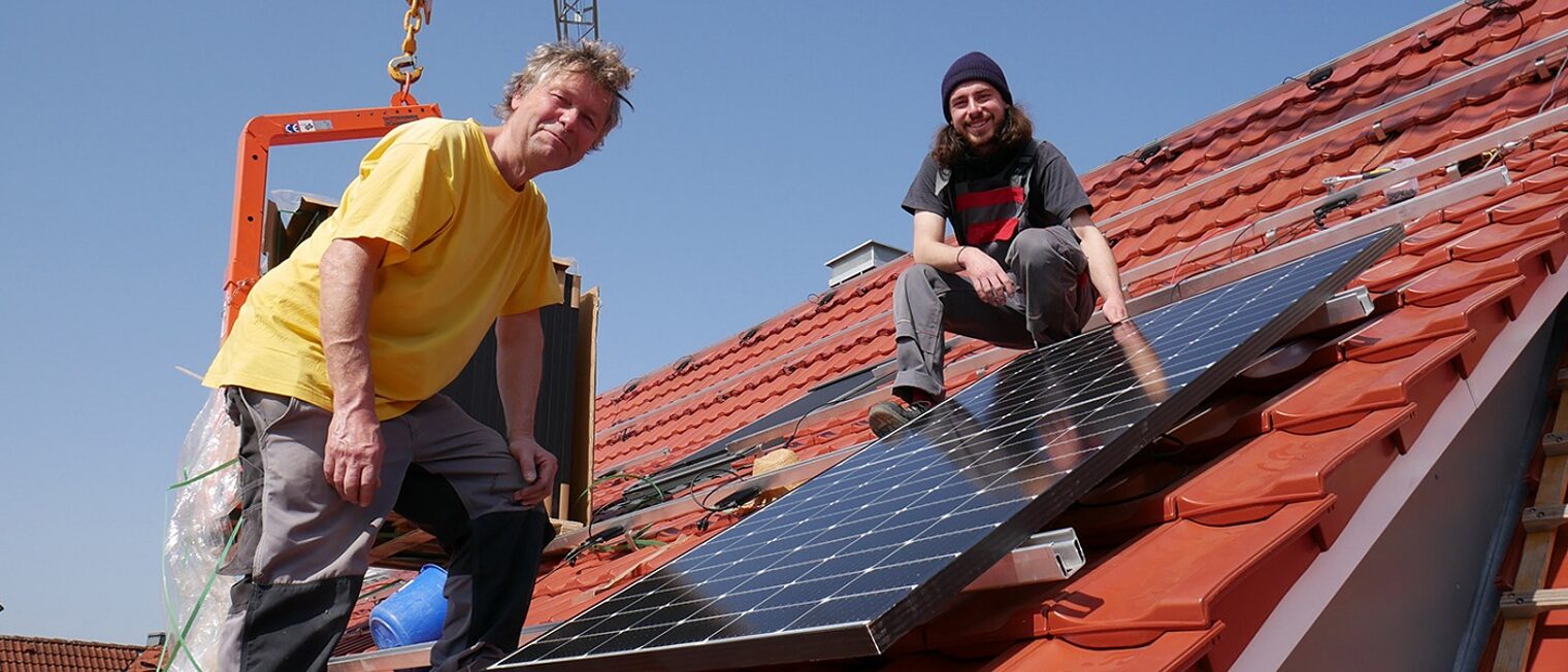 Michael Simon und Johannes Stiefel von Sunny Solartechnik auf einem Dach mit Solarpanel.