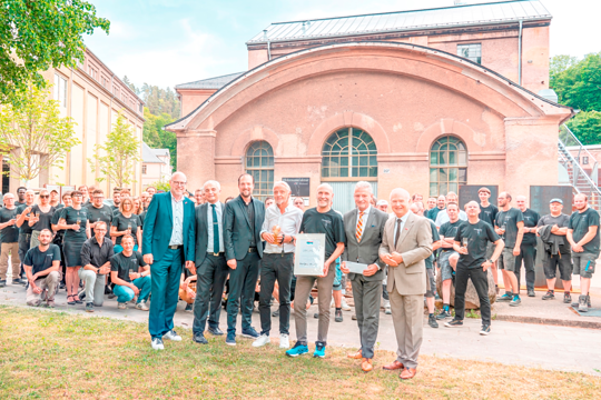 Team Holzmanufaktur Rottweil steht vor einem alten Gebäude.