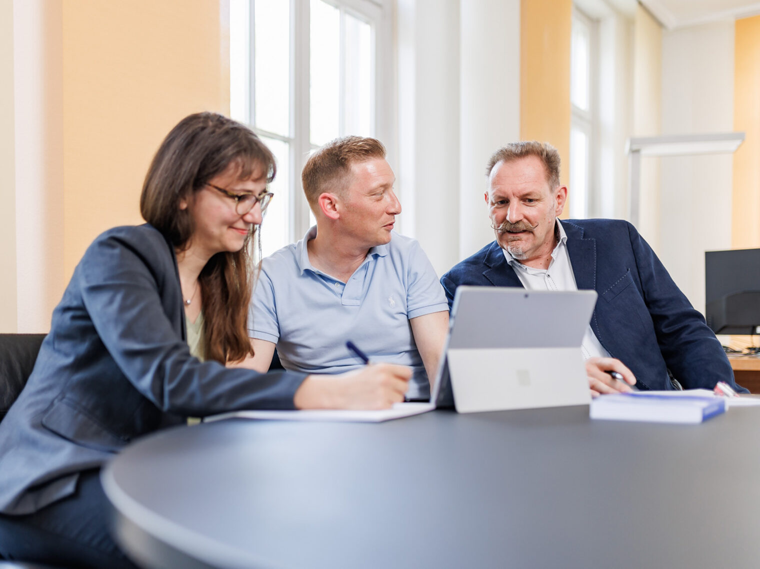 Viola Bischoff, Jan Benz und Peter Schürmann vom Unternehmensservice der Handwerkskammer Konstanz bei der Teamarbeit vor einem Tablet.