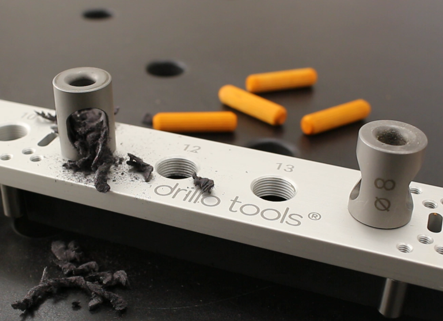 Der "Drillo": preisgekrönte Bohrschablone der Drillo Tools GmbH mit Dübel und Spänen.