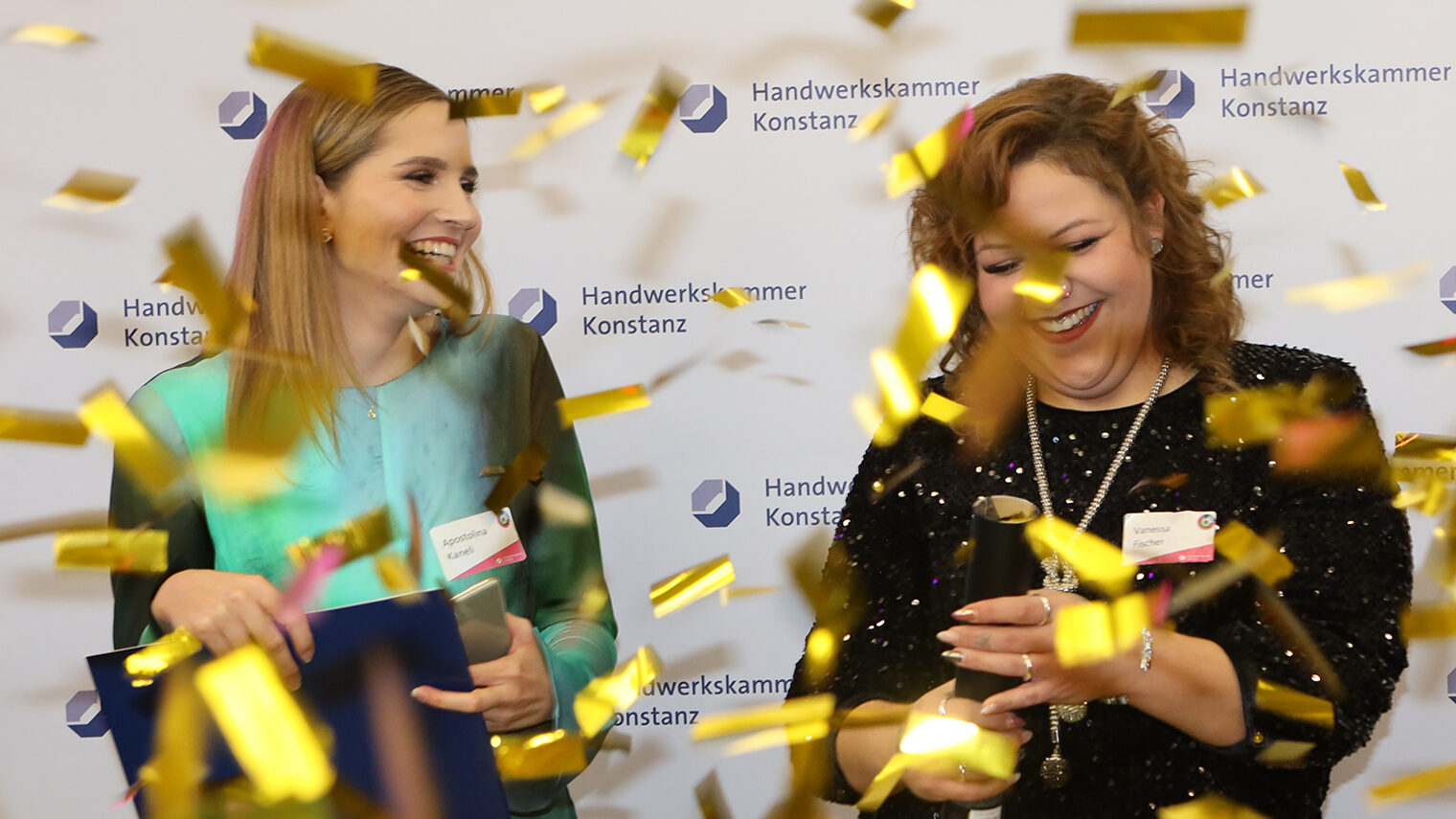 Zwei Friseurinnen auf der Meisterfeier 2022 der Handwerkskammer Konstanz im Goldregen.