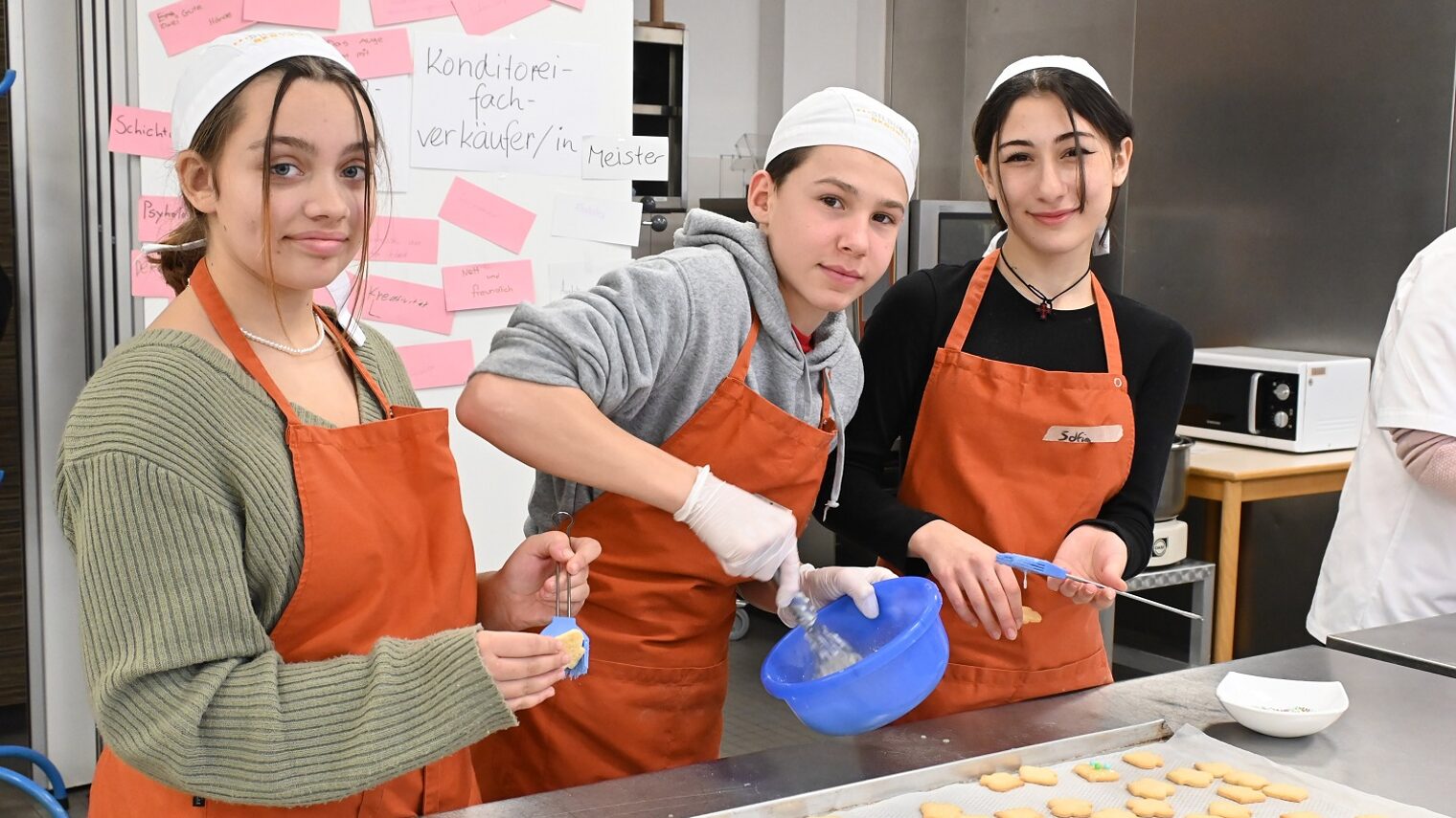 Zwei Mädchen und ein Junge beim Plätzchen backen