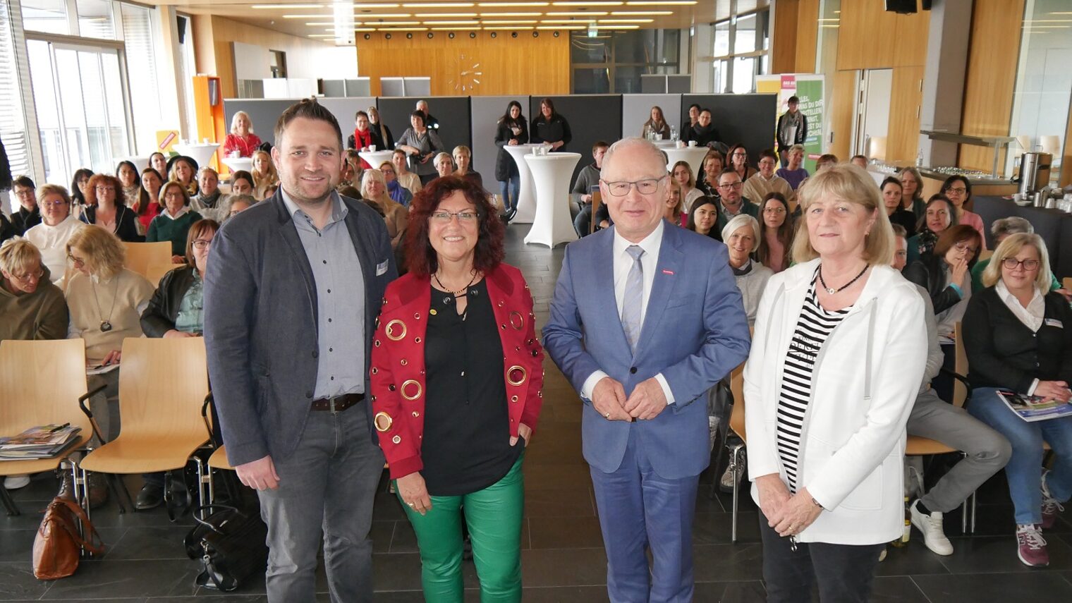 Gruppenbild mit vier Menschen im Vordergrund