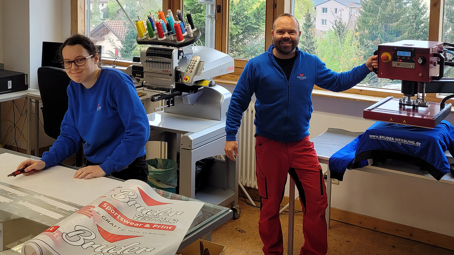 Elena Bocklet und Daniel Lehmann, Schilder- und Lichtreklamehersteller-Meister, beim Veredeln von Textilien. 