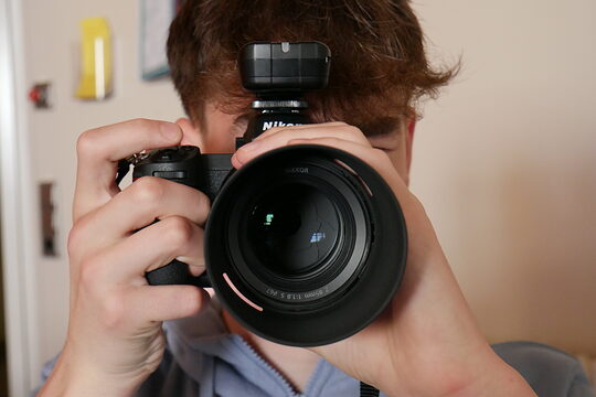 Ein Junge schaut durch einen Fotoapparat.