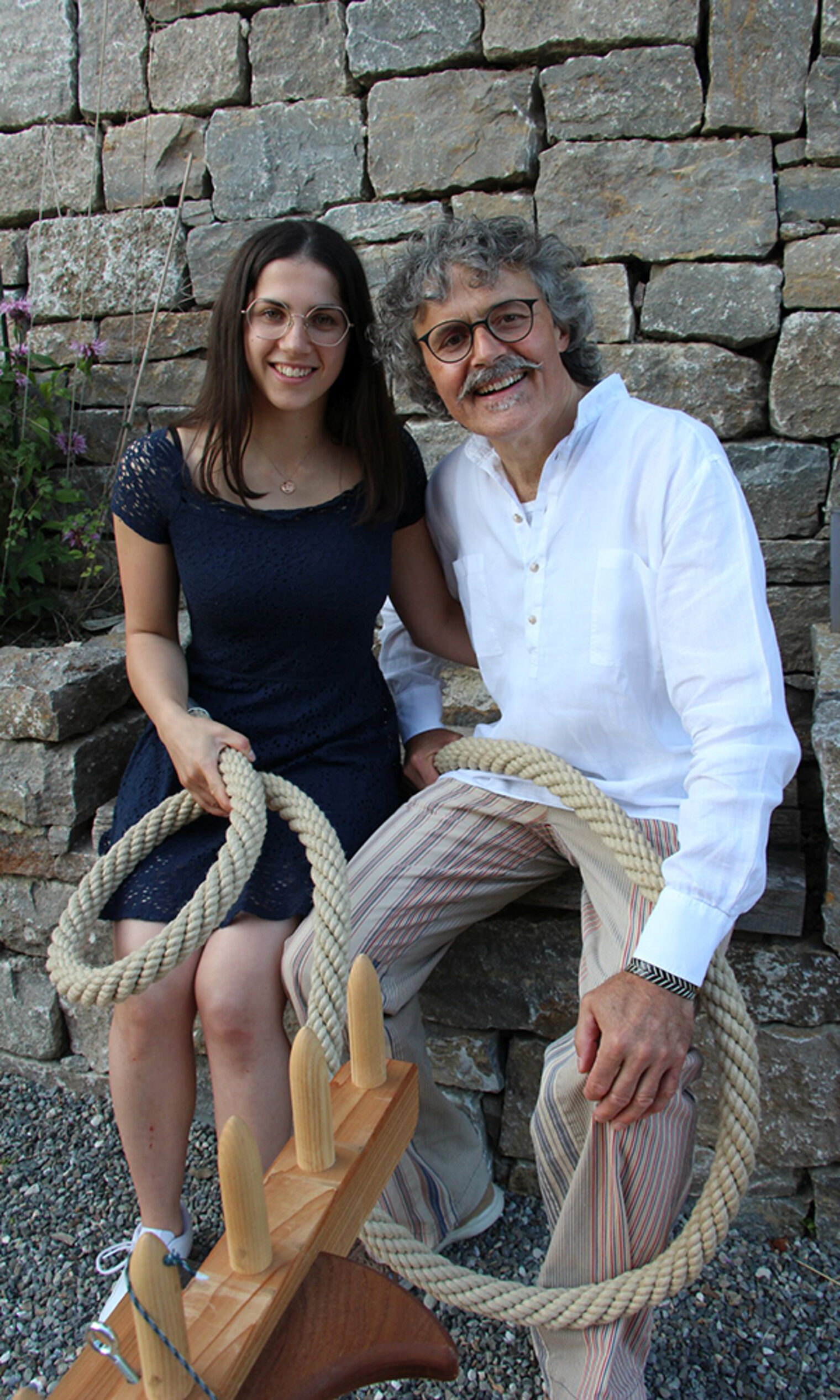 Sophie Muffler und ihr Vater Bernhard Muffler sitzen mit einem Tau in der Hand vor der Stockacher Stadtmauer.
