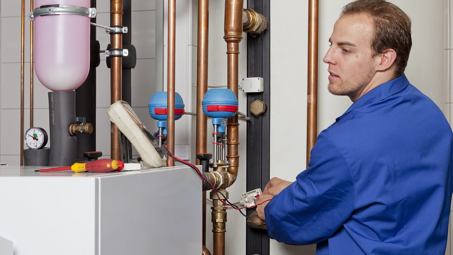 Mann kontrolliert Heizungsanlage