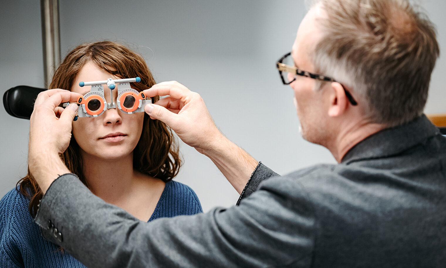 Augenoptiker misst die Sehstärke einer Kundin.
