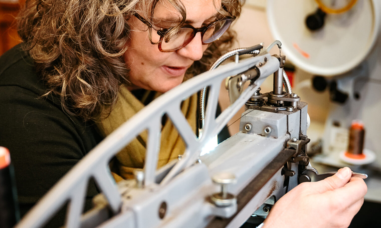 Schuhmacherin an Nähmaschine.