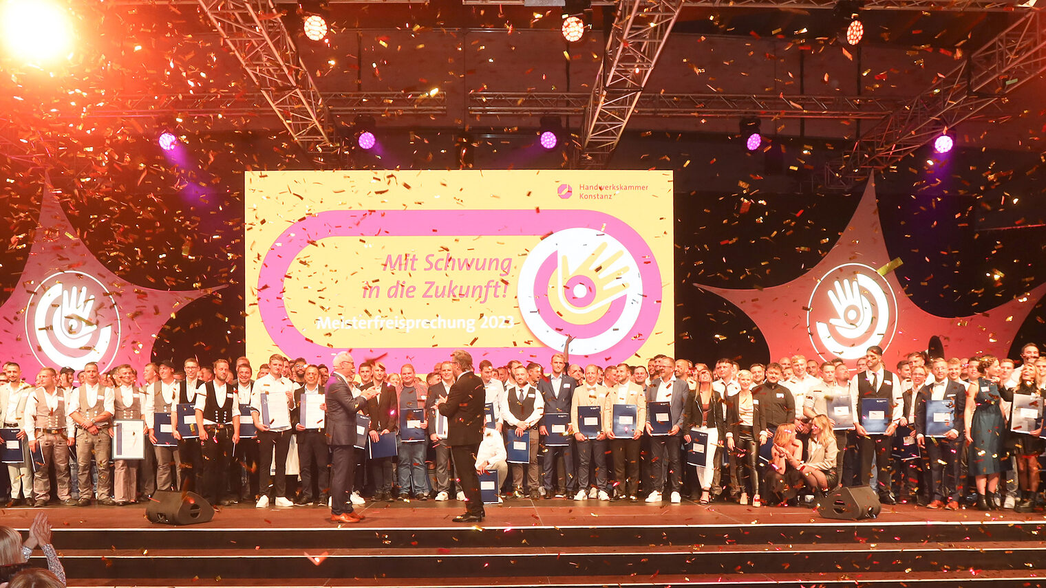 Gruppenfoto der Meisterinnen und Meister auf der Meisterfeier 2023, Bühne mit Goldregen