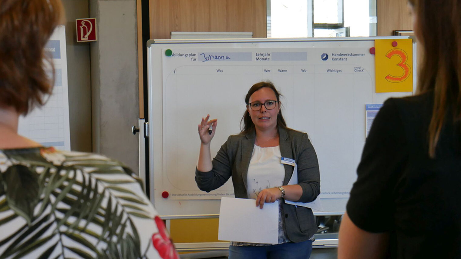 Fabienne Gehrig steht vor einem Flipchart und erklärt den betrieblichen Ausbildungsplan.