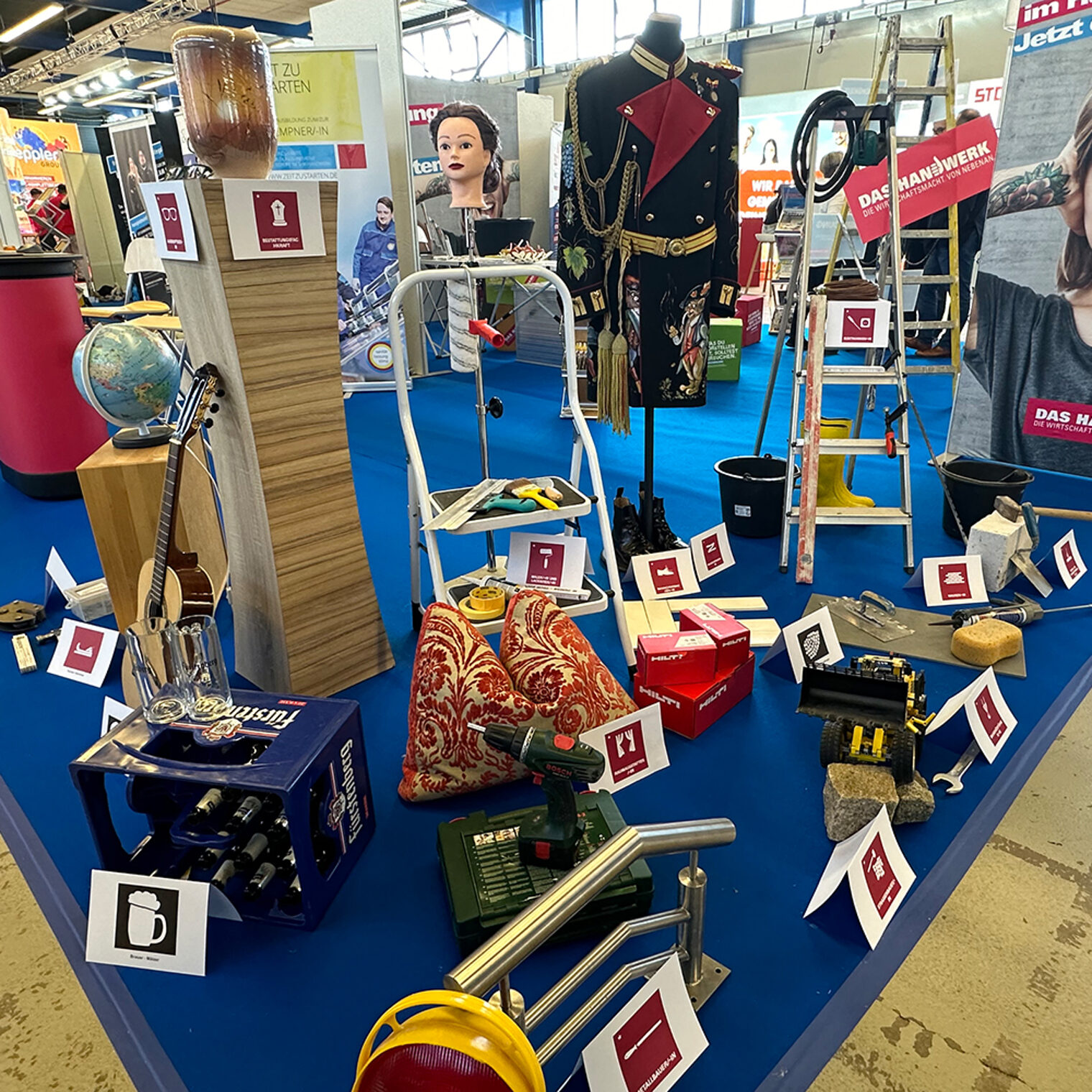 Berufsmesse Jobs für Future in Villingen: Stand des Handwerks mit exemplarischen Stücken, z.B. Kissen, Bohrmaschine, Bierkasten, Gitarre, Maler-Utensilien.