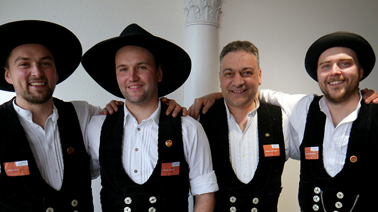 Gruppenbild vom Zimmerertreff mit Bildungsakademie-Leiter Filippo Campagna und drei weiteren Zimmerern, alle in der traditionellen Kluft.