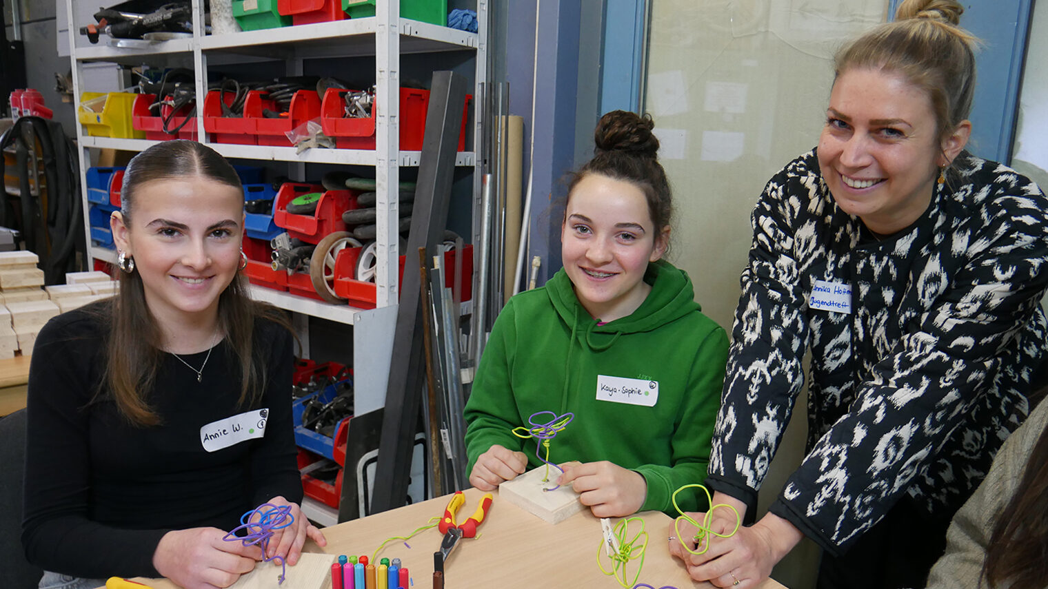 Annika Hoffmann vom Jugendtreff Berchen mit zwei Mädchen an einem Tisch beim Girls Day.