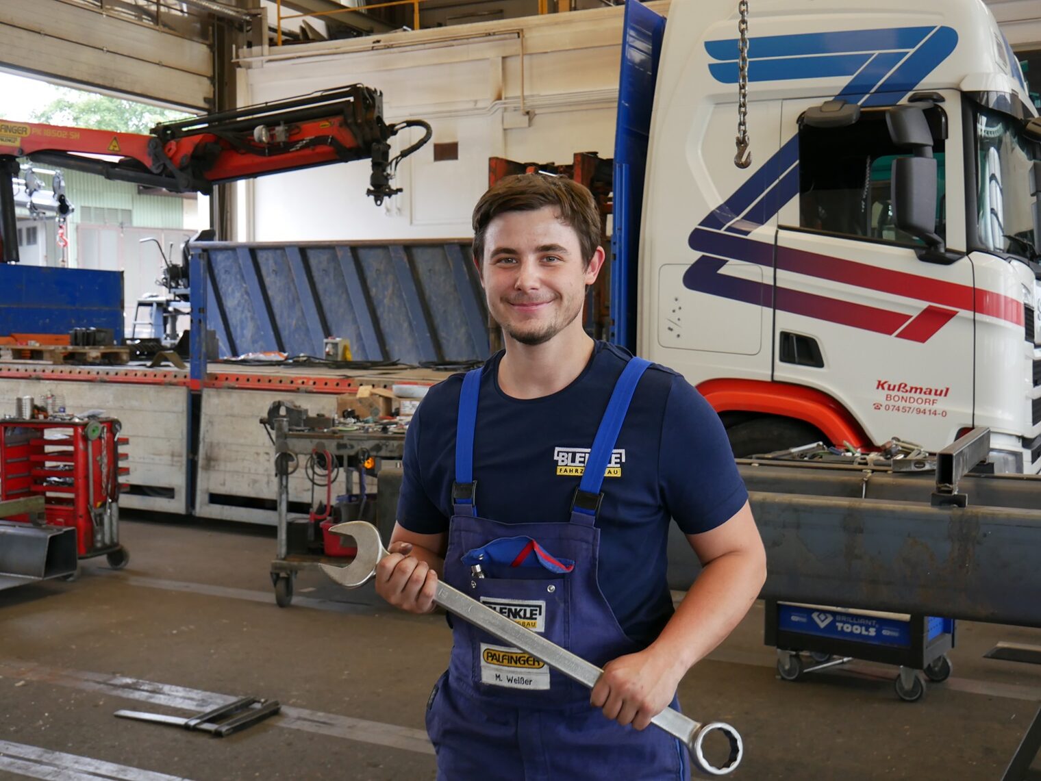 Junger Mann in Fahrzeugwerkstatt