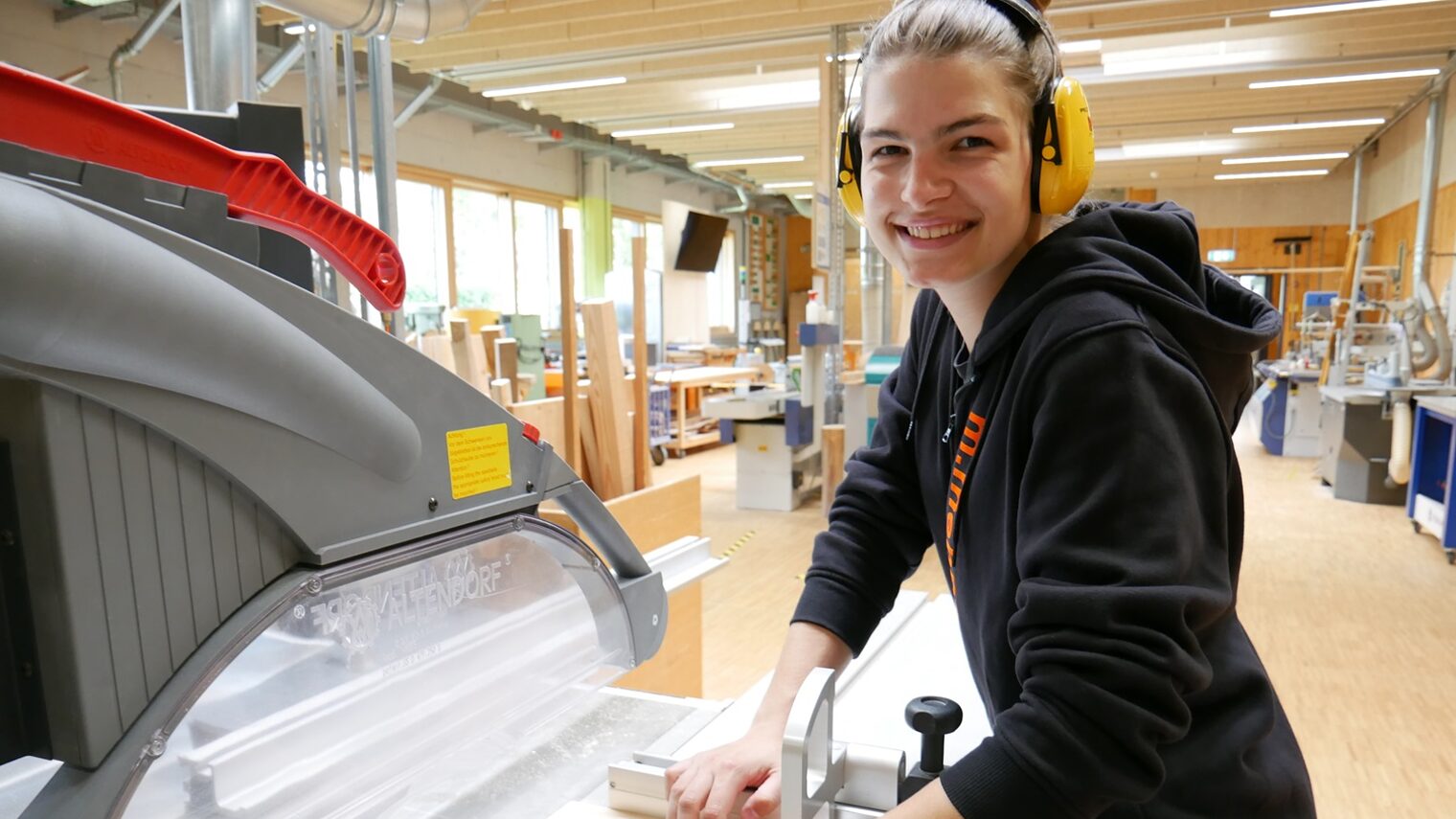 Junge Frau in Schreinerwerkstatt