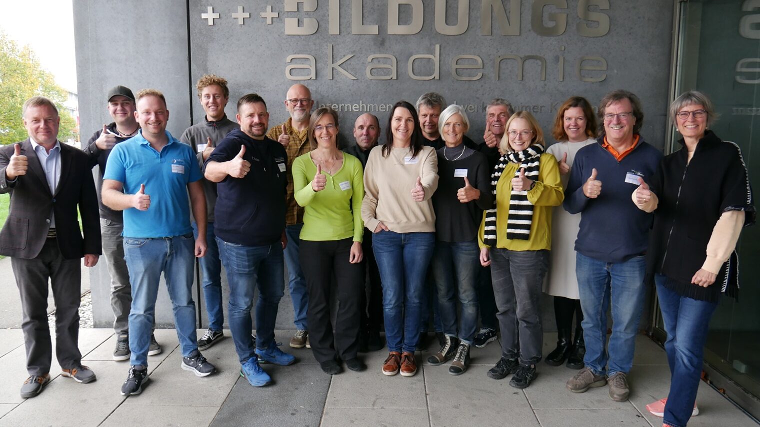 Gruppe von Menschen vor dem Logo der Bildungsakademie Singen