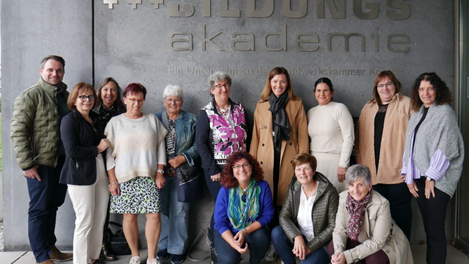 Gruppe von Frauen und einem Mann vor dem Logo der Bildungsakademie Singen