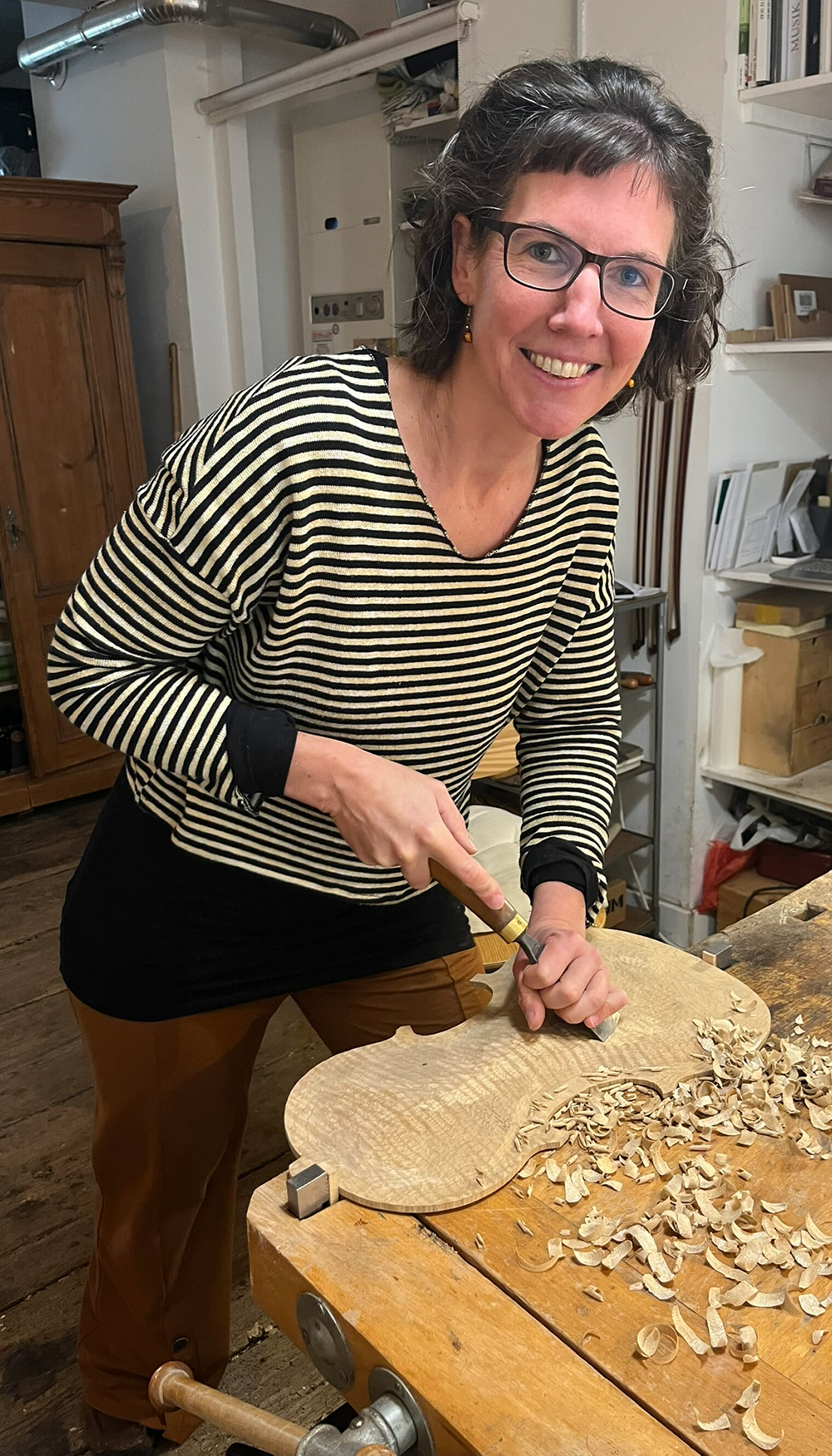 Geigenbauerin Ruth Pabel arbeitet in ihrer Konstanzer Werkstatt mit einem Stecheisen einen Bratschenboden aus.