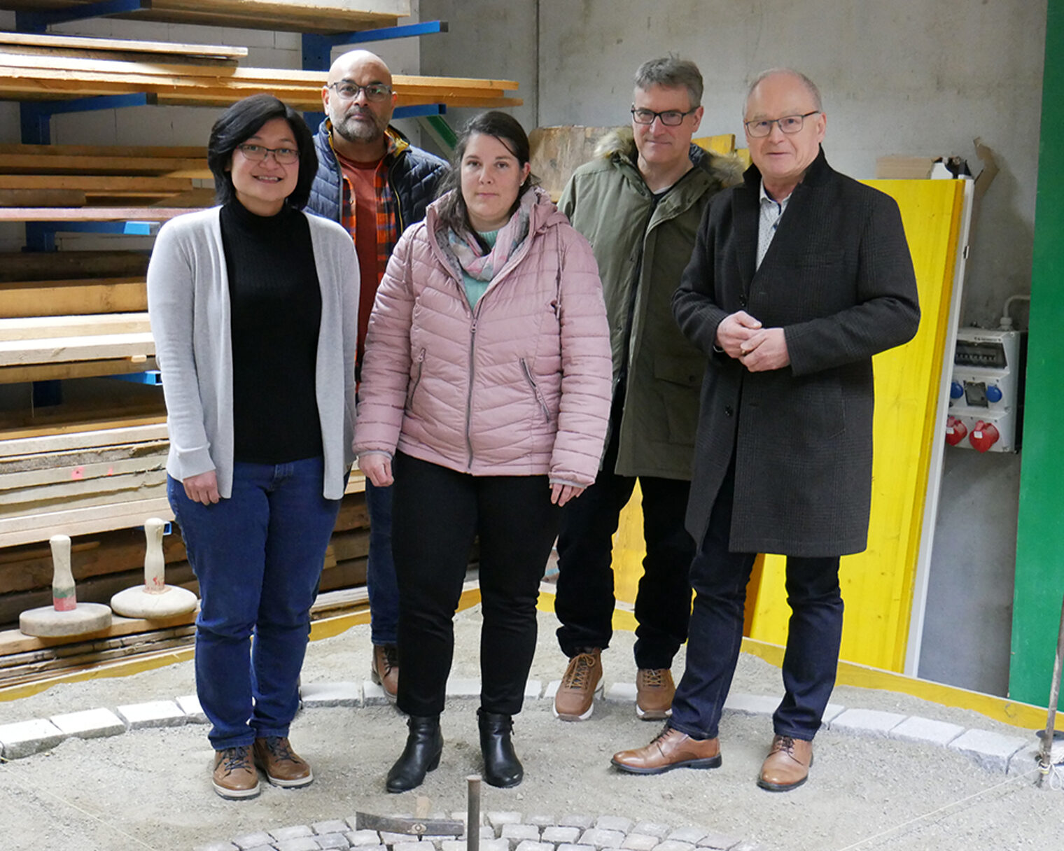 Gruppenbild mit indonesischer Auszubildender in der Lehrwerkstätte von Walter Straßenbau.