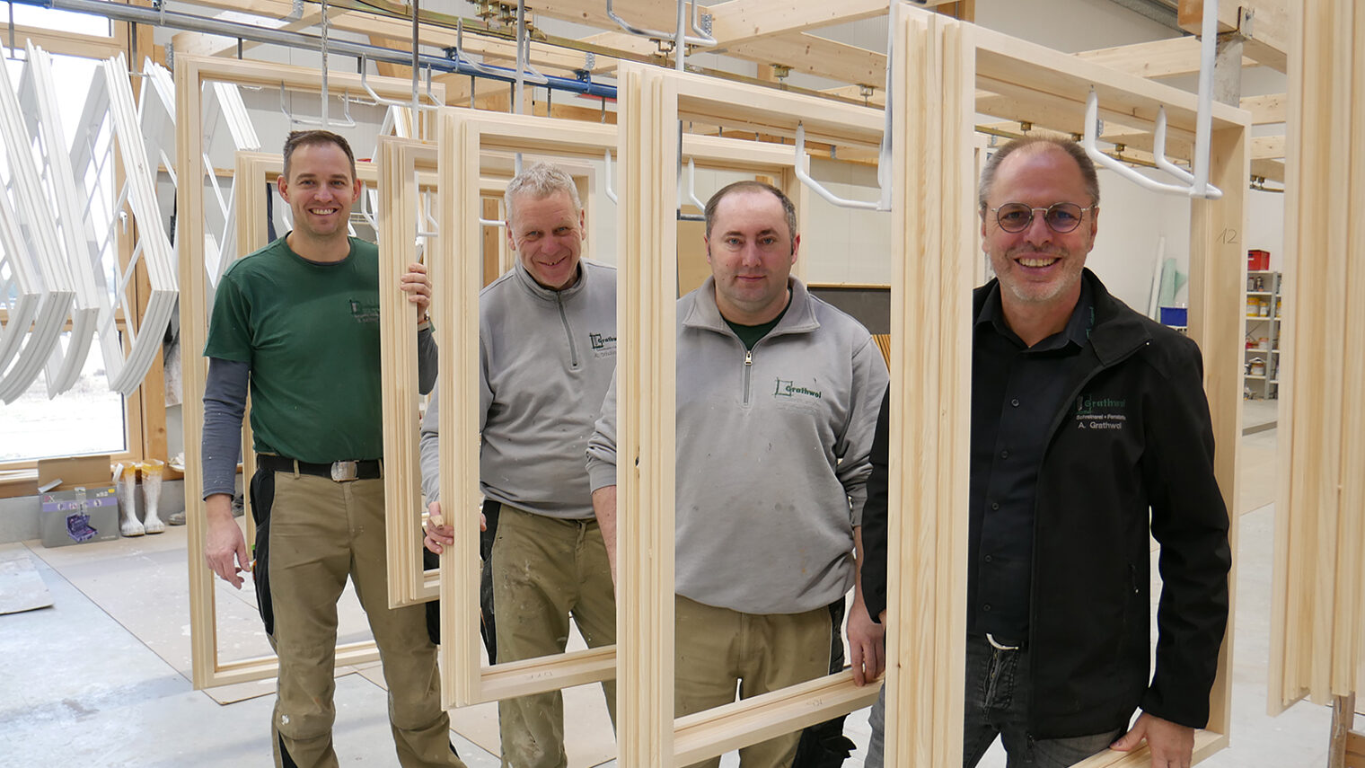 Fensterbaumeister Axel Grathwol und seine Mitarbeiter Sven Kimmich, August Schuhmacher und Theodor Schneider mit Fensterrahmen.