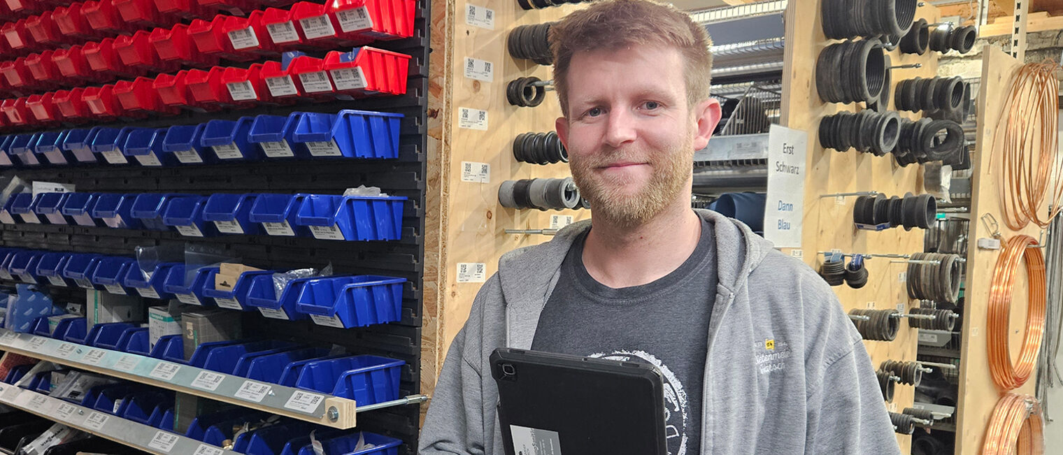 Lukas Kopp mit Tablet in der Hand im Lager von Dietermeier und Harsch.