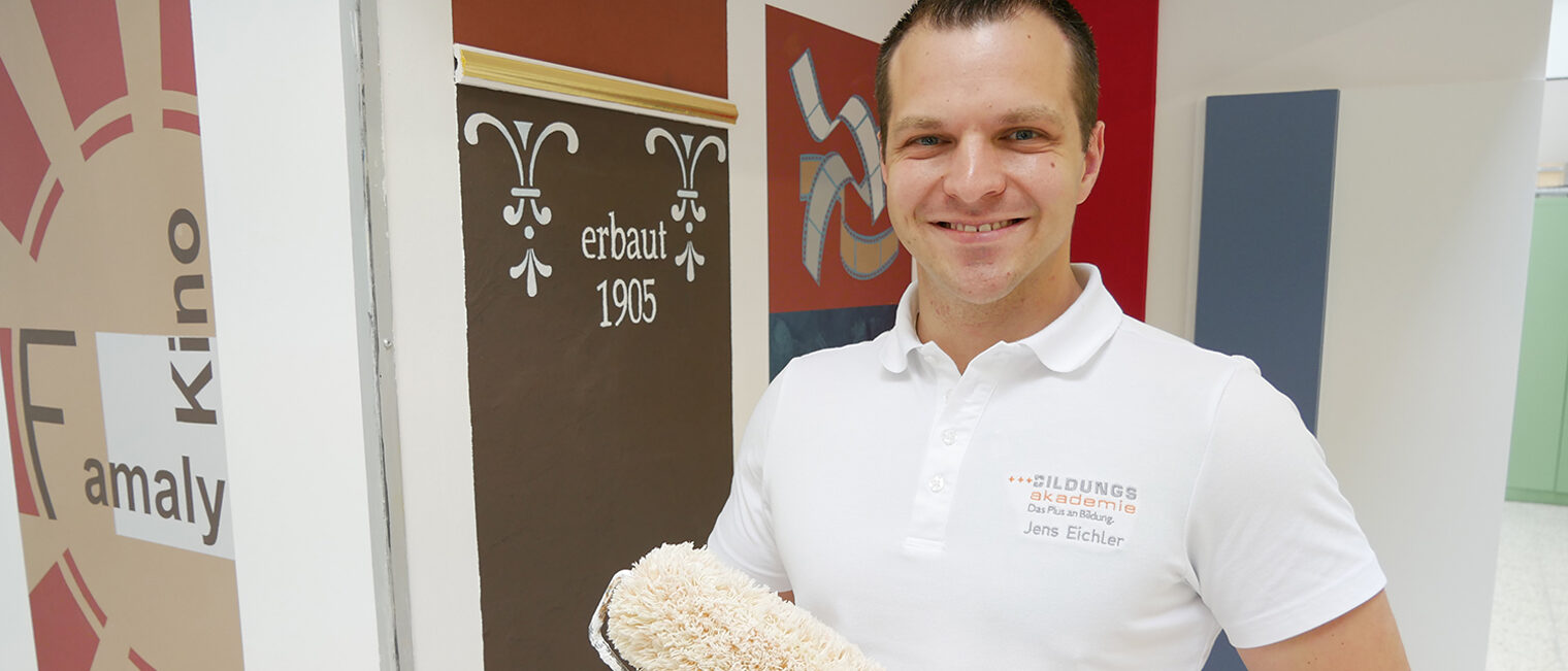 Portrait von Jens Eichler mit Malerrolle in der Hand.