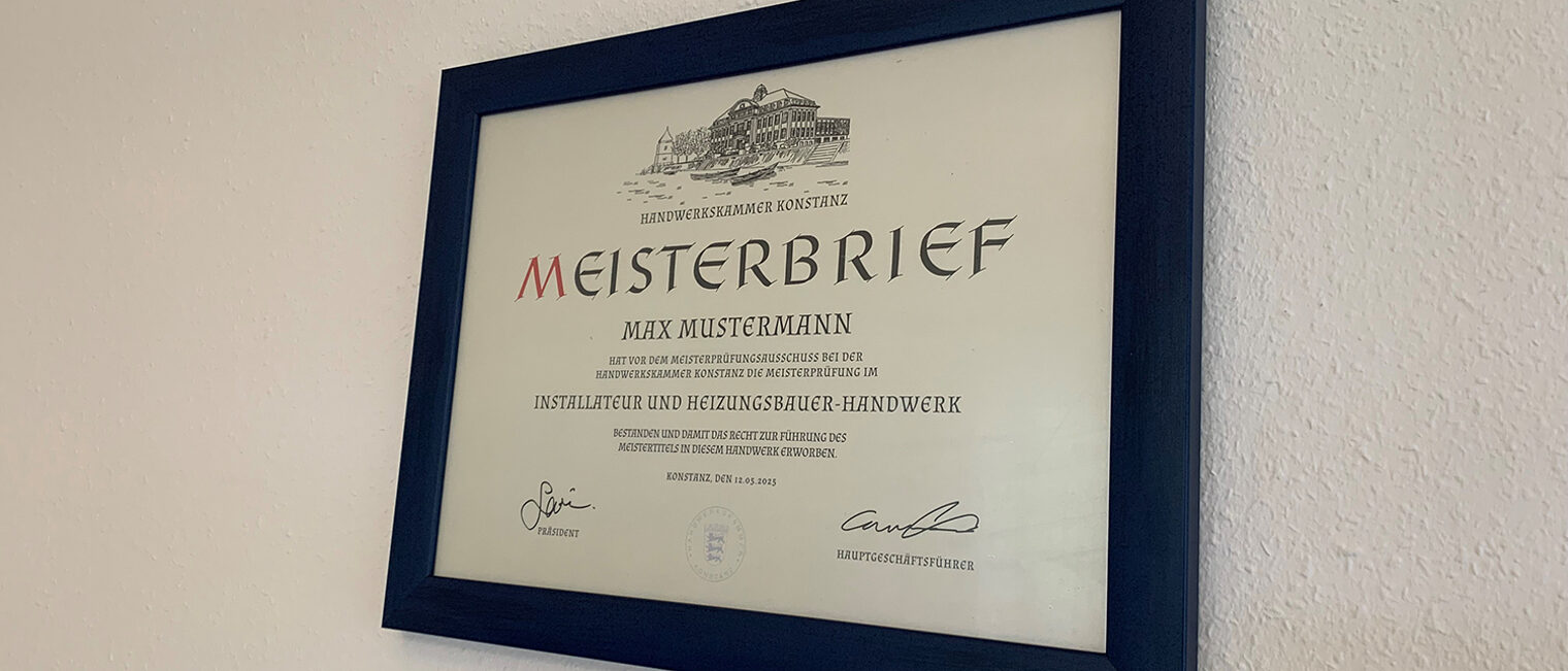 Gerahmter traditioneller Meisterbrief der Handwerkskammer Konstanz an einer weißen Wand.