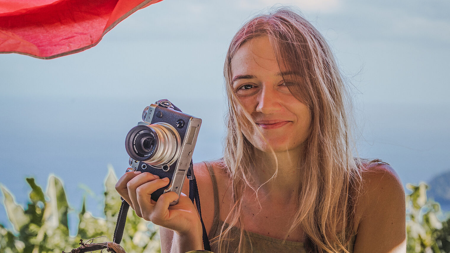Portrait der Fotografin Denise Speck mit Fotoapparat in der Hand