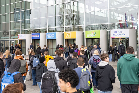 Besucher strömen in das Messegebäude der IHM in München.