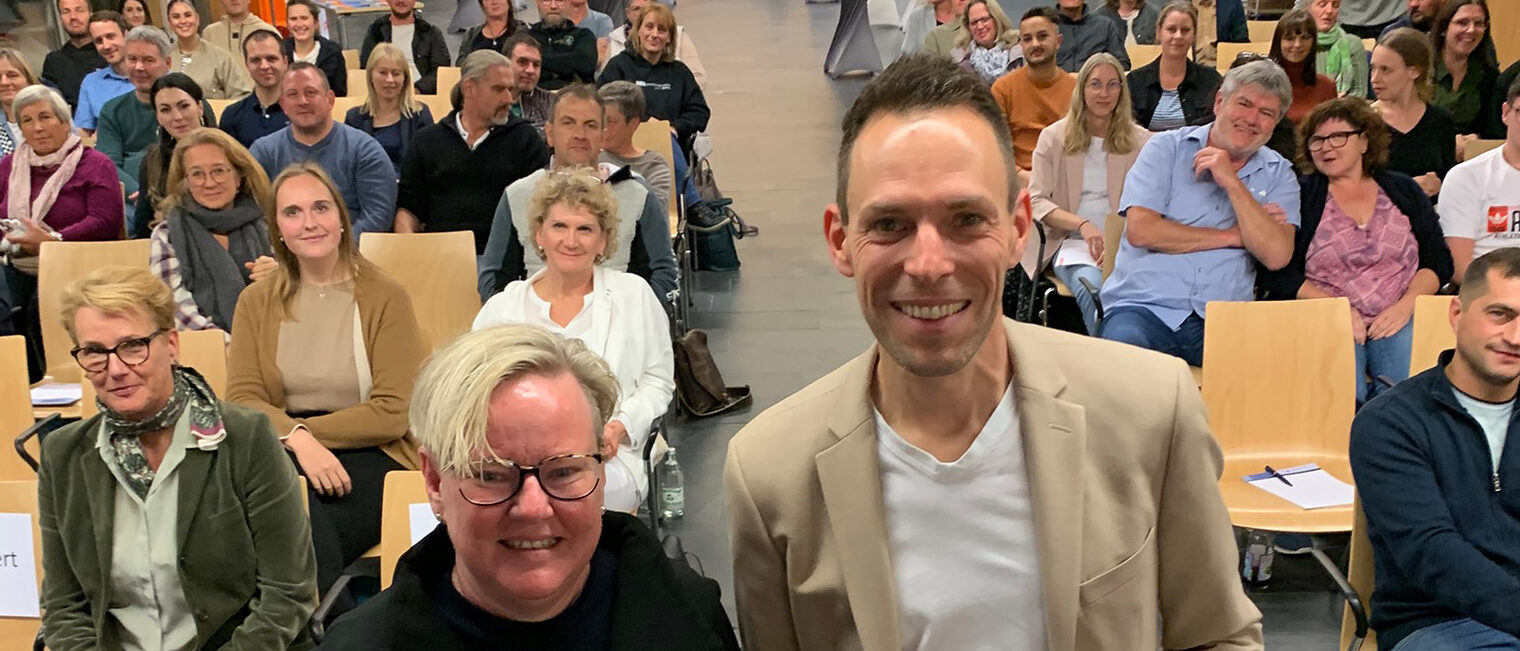Alexandra Hagen-Ettl und Felix Behm vor dem Publikum im Foyer der Bildungsakademie Singen.