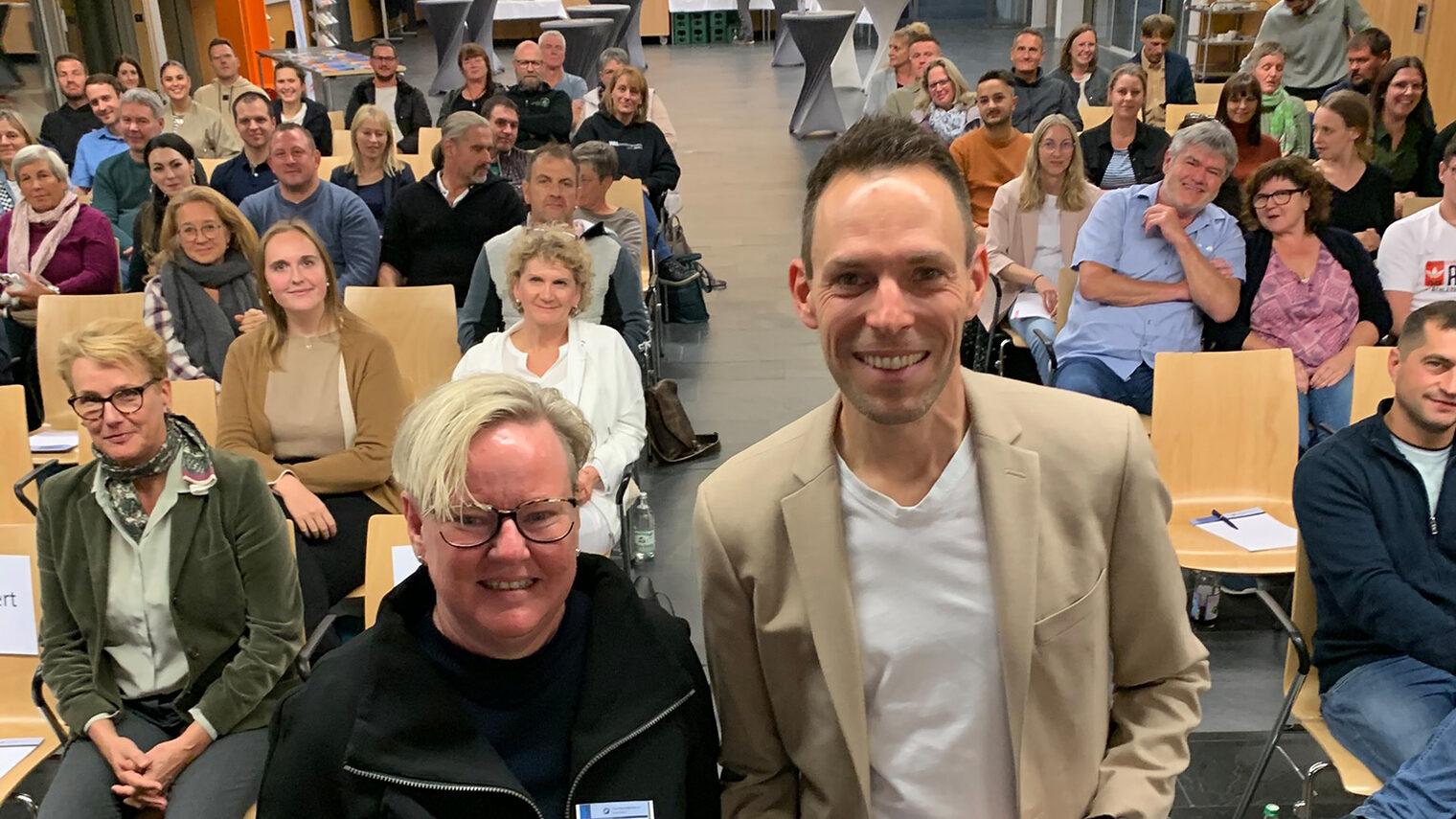 Alexandra Hagen-Ettl und Felix Behm vor dem Publikum im Foyer der Bildungsakademie Singen.