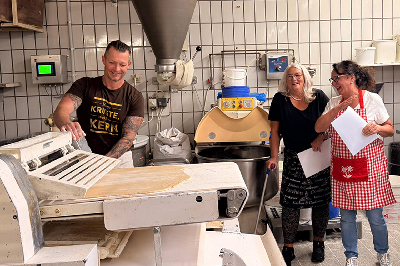 Bäckermeister Manuel mit Teilnehmerinnen seines Backkurses in der Backstube.