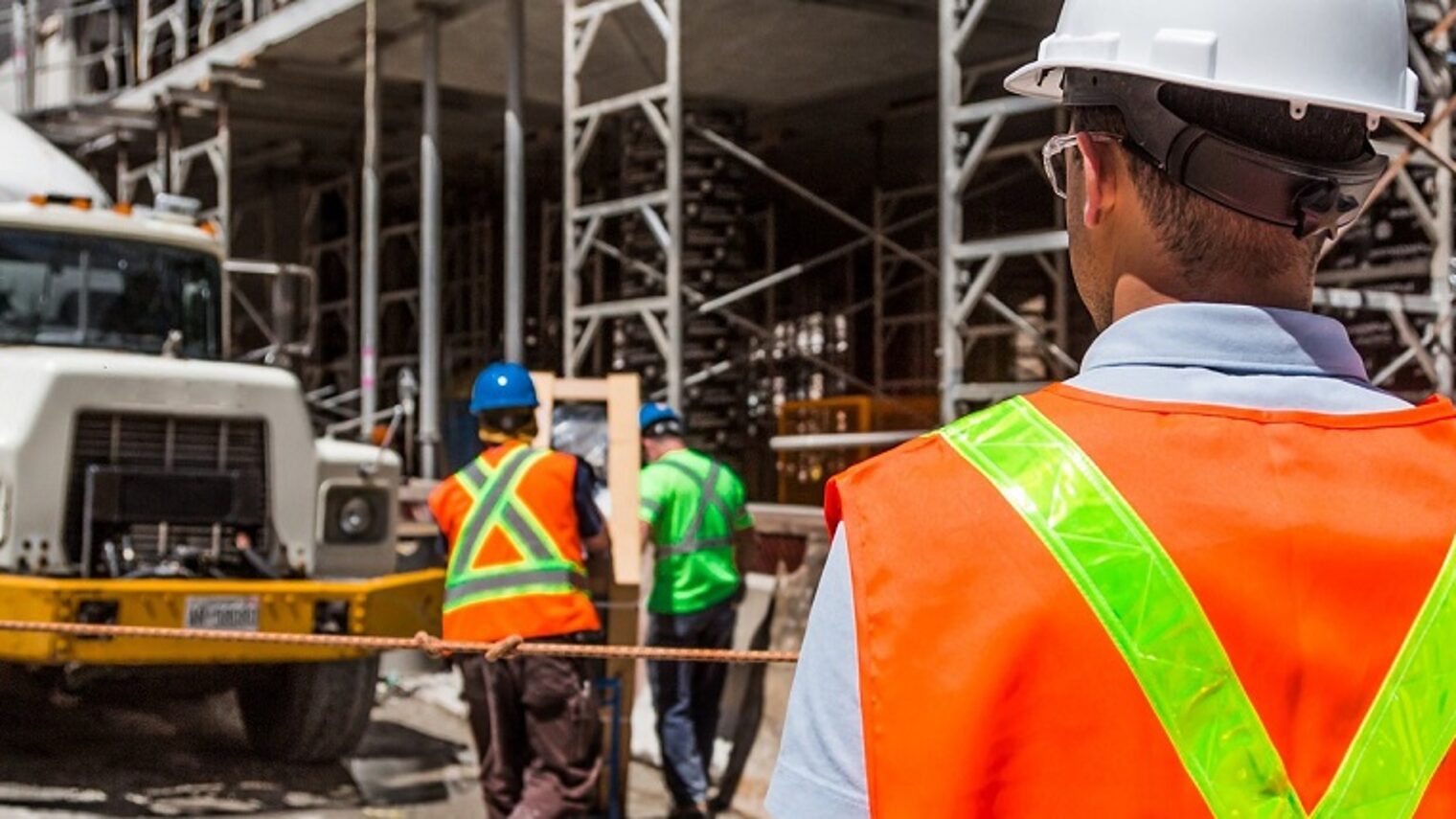 Betonmischer und Bauarbeiter auf Baustelle