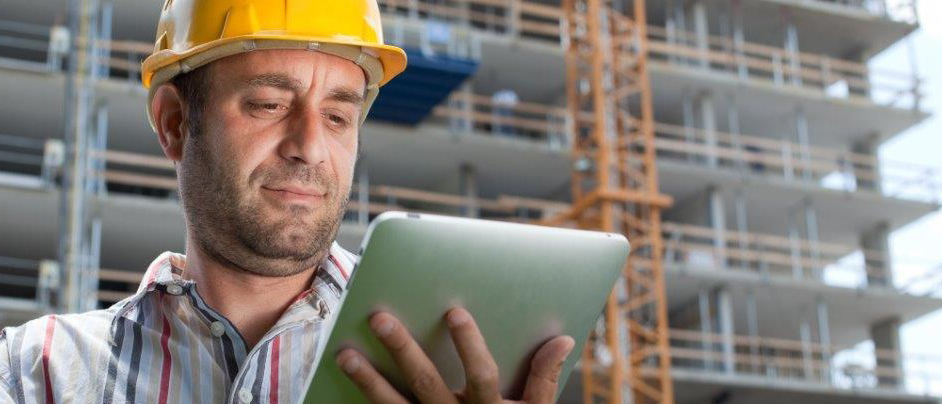 Bauarbeiter mit Tablet in der Hand auf einer Baustelle