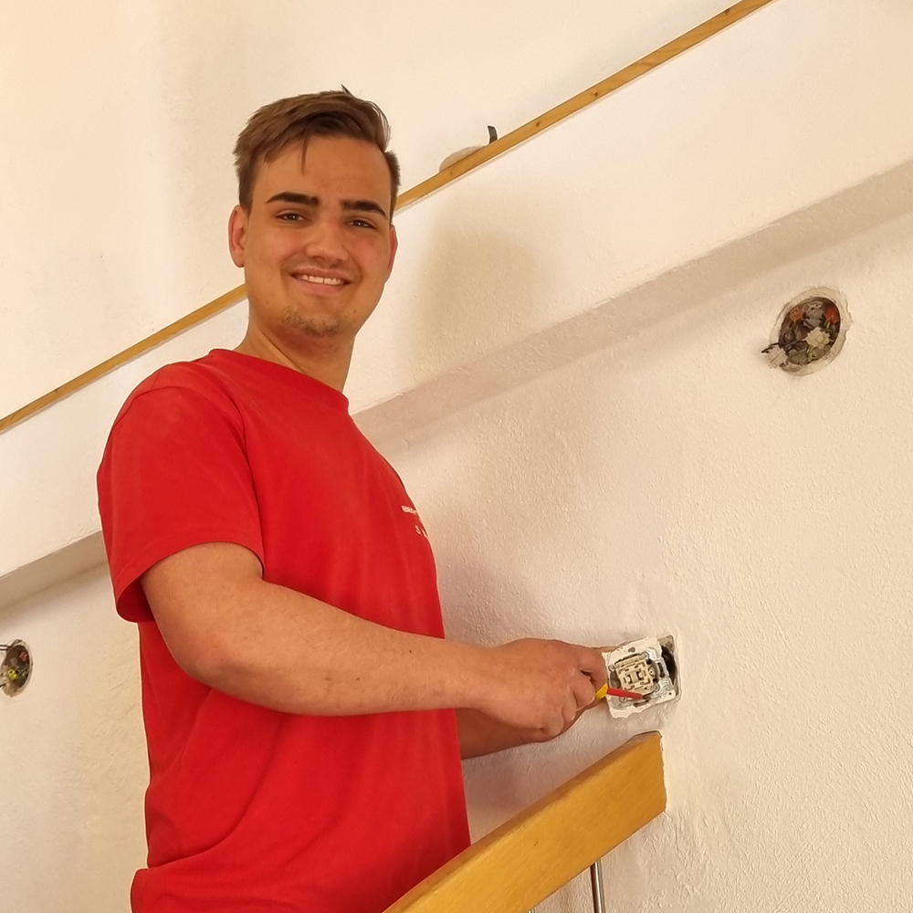 Simon Mauch, angehender Elektroniker für Energie- und Gebäudetechnik, montiert eine Steckdose.