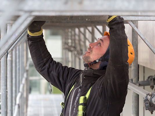 Junger Gerüstbauer bei der Arbeit