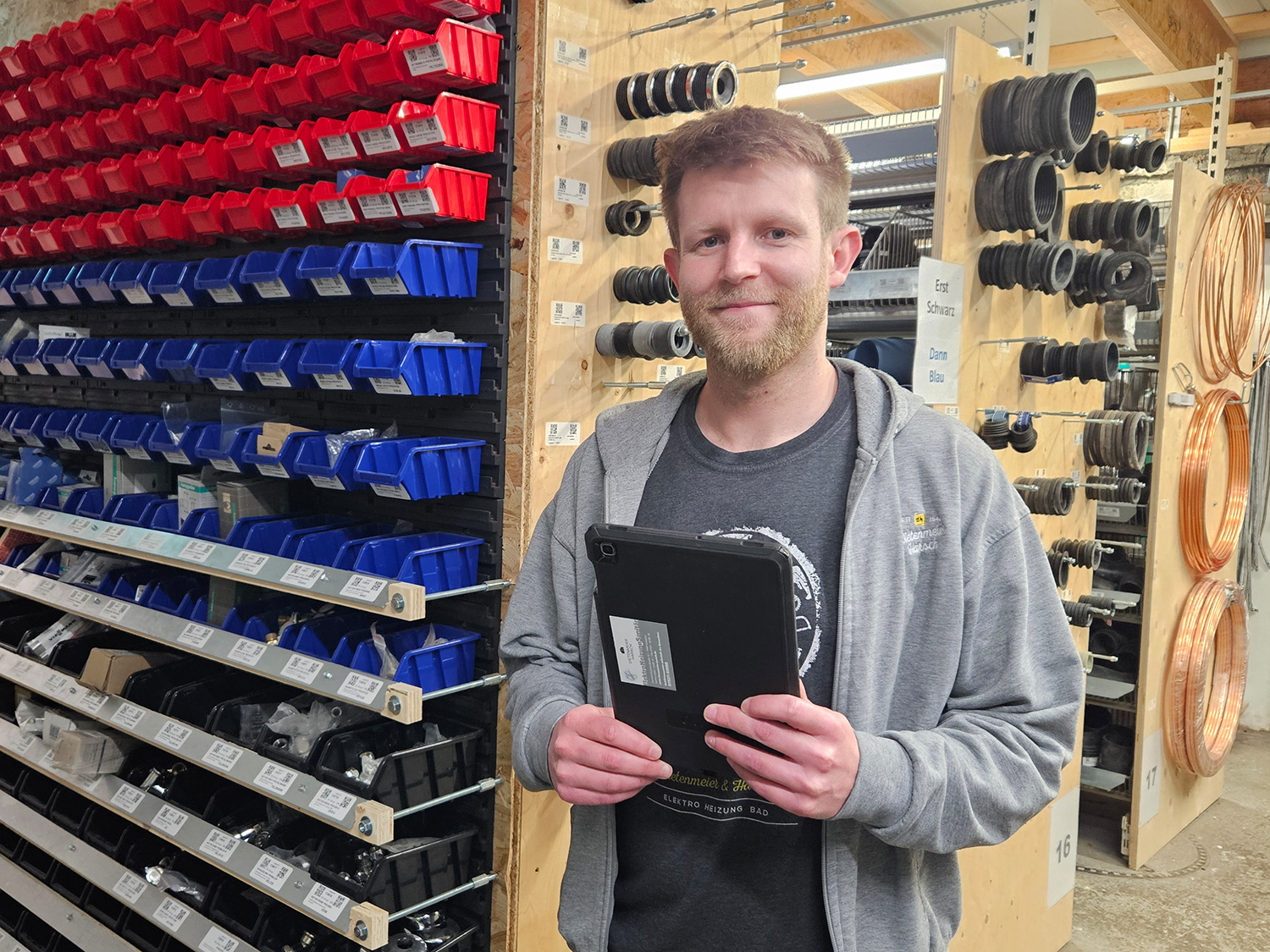Lukas Kopp mit Tablet in der Hand im Lager von Dietenmeier und Harsch.