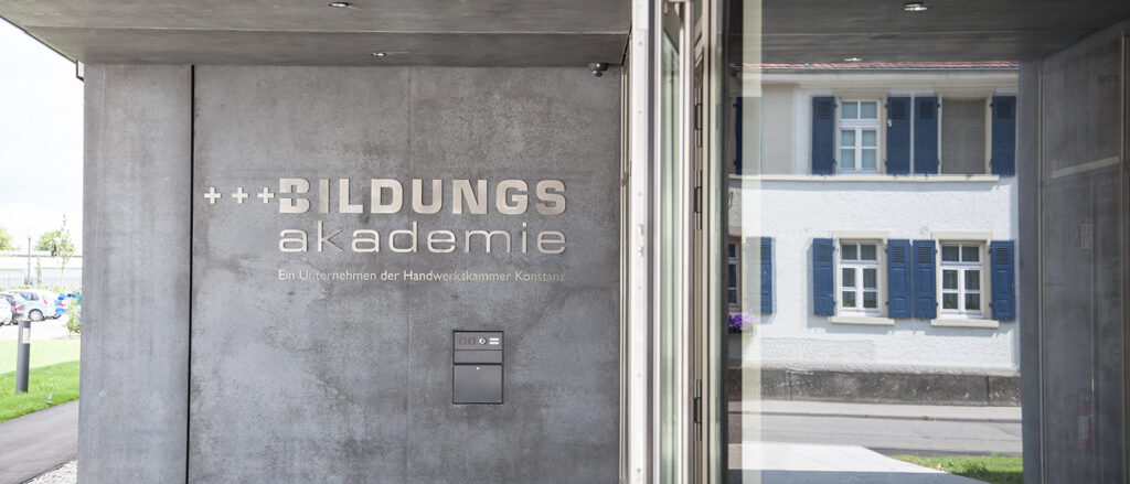 Schriftzug Bildungsakademie - Ein Unternehmen der Handwerkskammer Konstanz an der Fassade im Eingangsbereich der Bildungsakademie Singen.